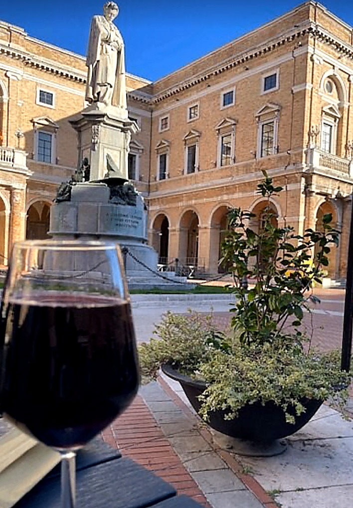 Calice di vino rosso ai tavoli esterni dell'osteria